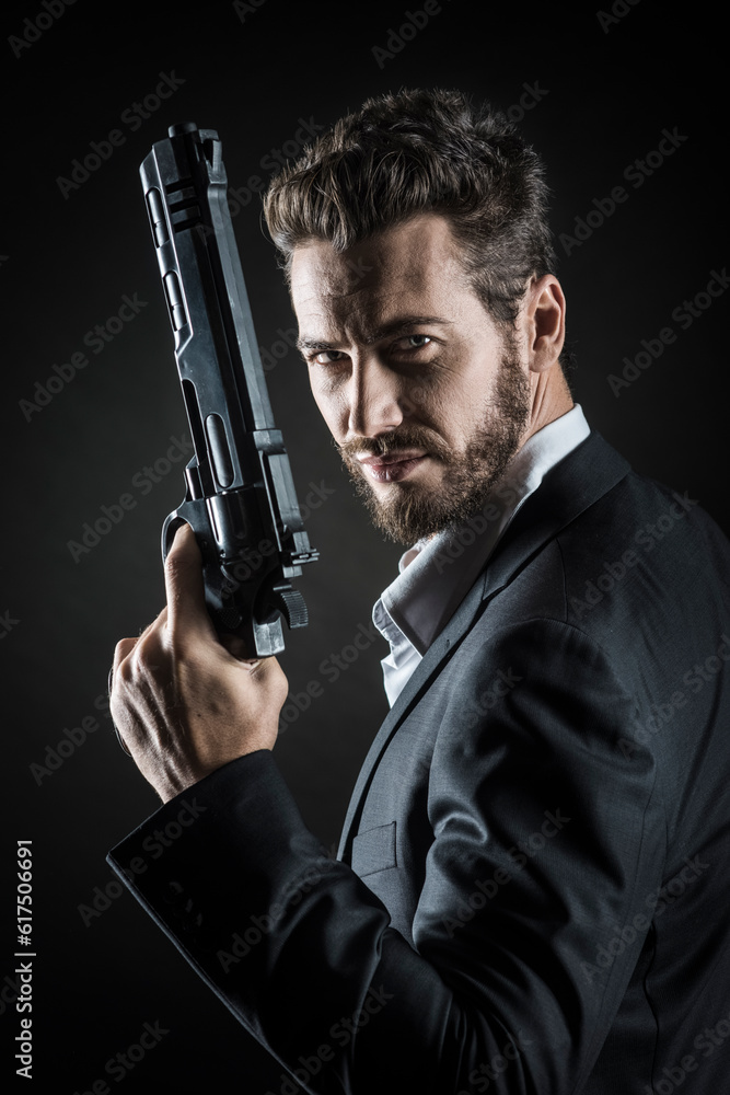 Brave cool man holding a dangerous weapon on dark background Brave cool man holding a dangerous weapon on dark background