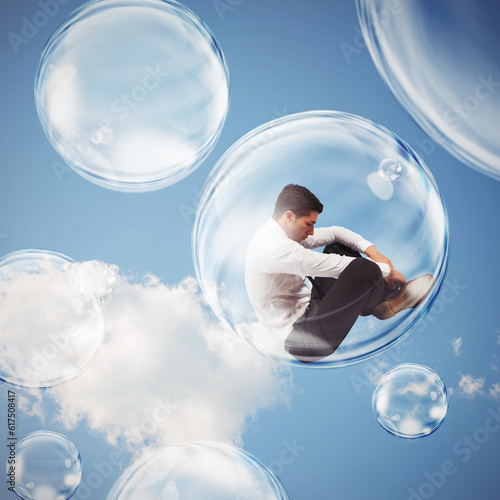 Sad businessman flies in a bubble. isolate themselves inside a bubble detachment from the outside world concept © Designpics