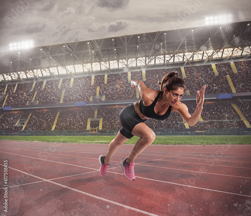 Athletic woman runs in a sport competition on the stadium track