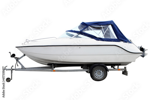 White motor boat with a blue awning loaded on a trailer for transportation.
