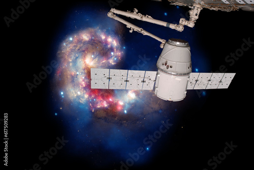 SpaceX Dragon over spiral galaxy. Elements of this image furnished by NASA.