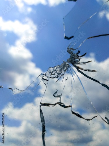 Glass broken by explosion against blue sky. Soft focus background 
