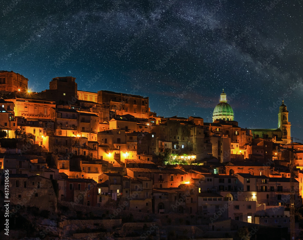 Night old medieval Ragusa Ibla famos Sicilian town view (Sicily, Italy) and Milky Way stars above. City lights of famous touristic destination. Unesco world heritage site.