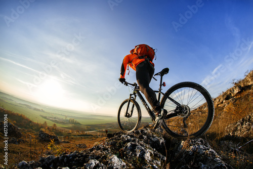 back view of a man with a bicycle and red backpack against the blue sky. cyclist rides a bicycle. Rear view people collection. backside view of person. blue sky background and mound.