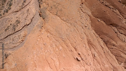 Flight over a desert rocky terrain covered with red sand. Desert landscape shot from above in 4K