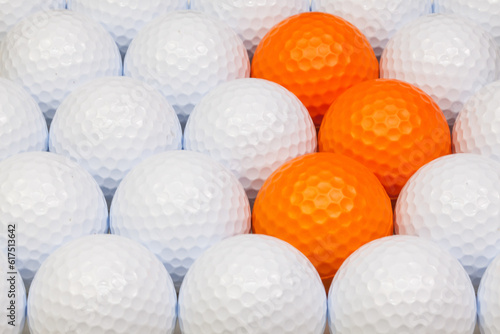 White and orange golf balls in the open box