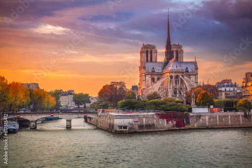 Cityscape image of Paris, France with the Notre Dame Cathedral during sunset.