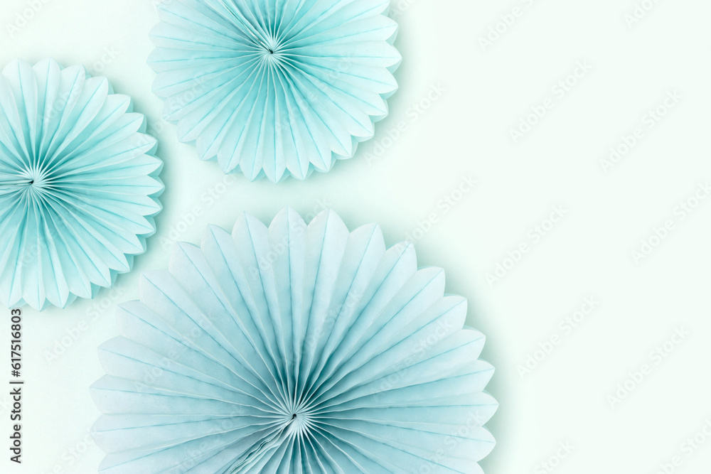 Tissue paper fans on a blue background. Festive composition with copy space.
