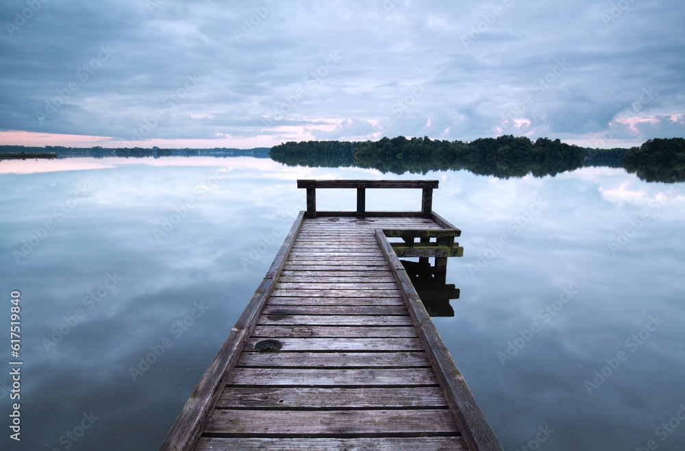 wooden pier on big lake during clouded day