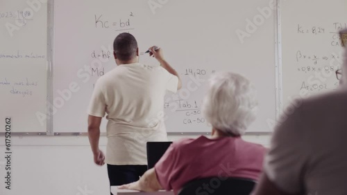 professor Brasileiro comemrorando tocando mãos com sua aluna idosa durante aula em curso para dultos em uma escola no Brasil photo