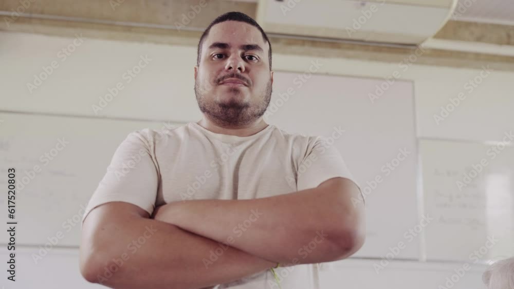 sorrindo de braços cruzados na sala de aula em um curso para adultos no Brasil
