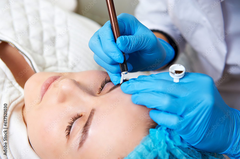 Permanent make-up master makes eyebrow correction procedure. Permanent makeup. Close-up. Permanent make-up master makes eyebrow correction procedure. Permanent makeup. Close-up.