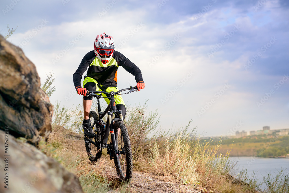 Professional Cyclist Riding the Bike at the Rocky Trail. Extreme Sport Concept. Free Space for Text.