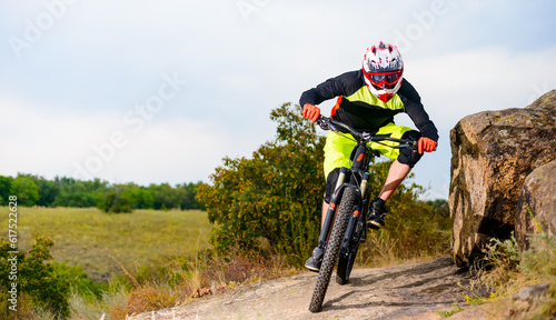 Professional Cyclist Riding the Bike at the Rocky Trail. Extreme Sport Concept. Free Space for Text.
