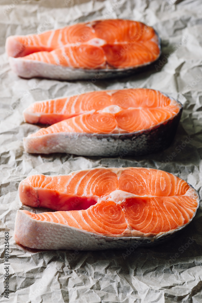 Three Raw Salmon Steaks on Parchment Paper. Vertical. Three Raw Salmon Steaks on Parchment Paper. Vertical.