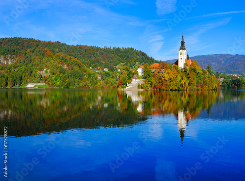 Church of Assumption in Lake Bled, Slovenia with blue sky and clouds in autumn light