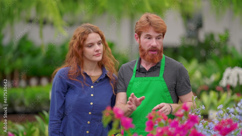 A male staff of Flower Shop speaking with female customer inside Horticulture gardening retail store