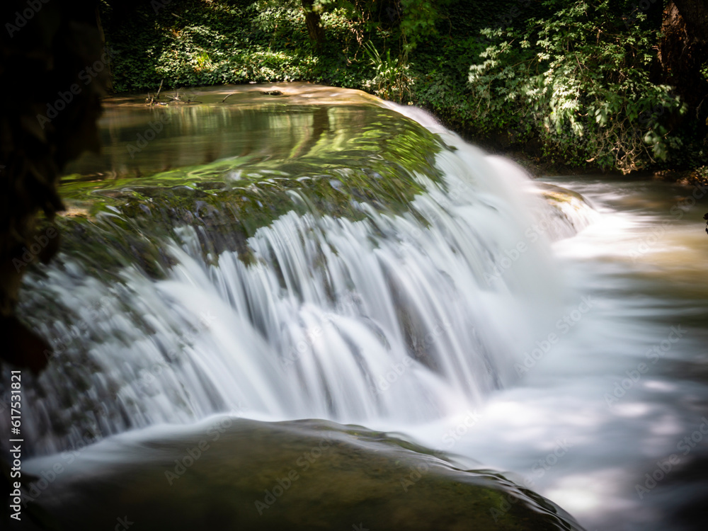 Stone monastery garden park with lush waterfalls