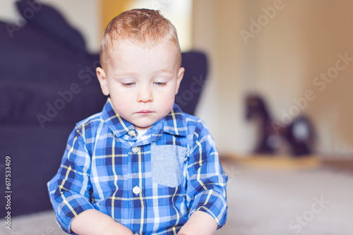adorable toddler with blue eyes being upset and unhappy at home, toned image