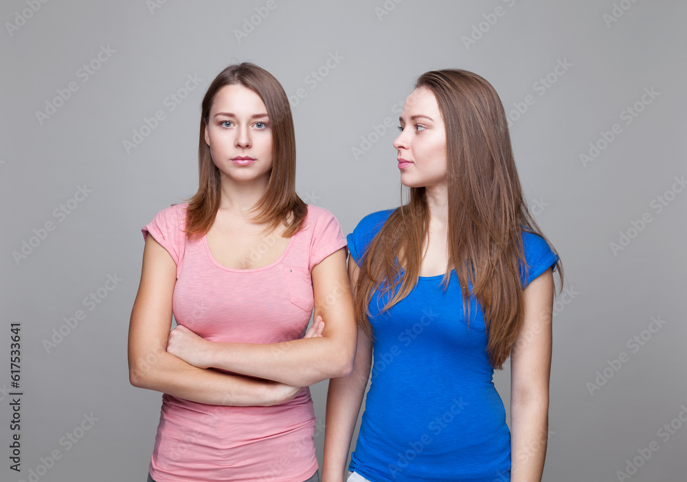 Studio portait of young and happy twin sisters Studio portait of young and happy twin sisters