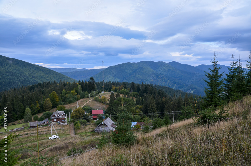 Beautiful scenic overcast countryside landscape with forested hills and mountain village Vorokhta down in the valley, Carpathian Mountains, Ukraine