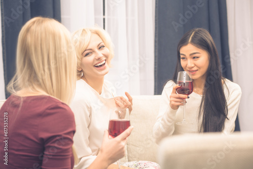 Toned picture of cheerful friends businesswomen having party at home. Beautiful ladies smiling and communicating about every day life: work, home, men.