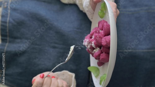 Italian gnocchi. Traditional Italian food in a bowl is held by a woman in an apron. Handmade potato balls with parmesan and beets. Food for vegetarians and lovers of Italian typical cuisine, 4k  photo