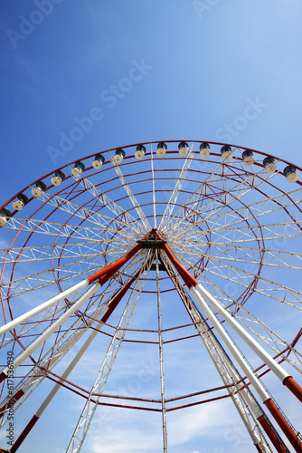 Ferris wheel and blue sky in sun day. Wide angle view.