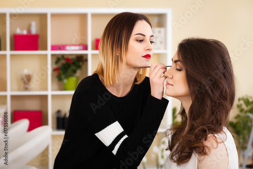make-up artist doing make-up girl in the salon, beauty concept and self-care