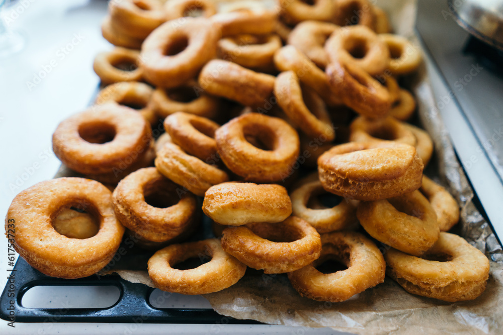 Fried donuts on a baking sheet. Donuts lie in several layers. Fried donuts on a baking sheet. Donuts lie in several layers.