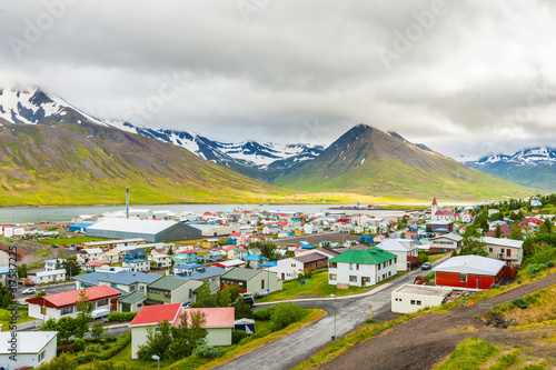 Mighty fjords with mountains covered by snow rise above the town of Olafsfjordur, Northern Iceland photo