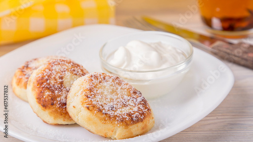 Cottage cheese pancakes with sour cream and powdered sugar. Breakfast concept