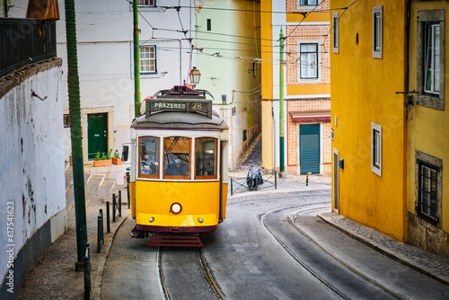 Famous vintage yellow tram 28 in the narrow streets of Alfama district in Lisbon, Portugal - symbol of Lisbon, famous popular travel destination and tourist attraction photo