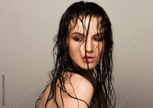 Beauty fashion model girl natural makeup wet hair  on grey background in warm tones photo