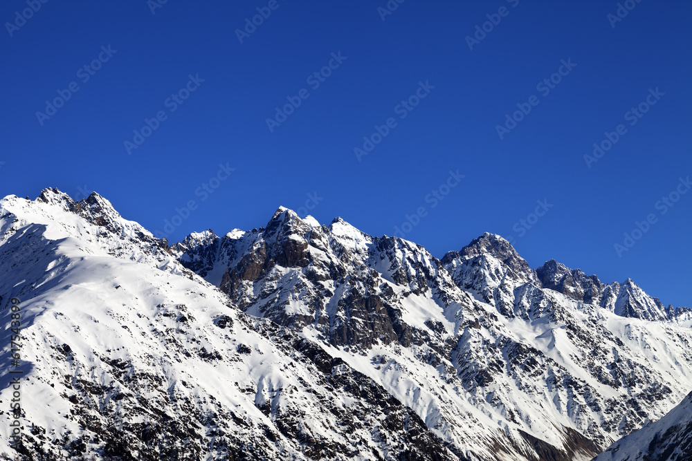 Snowy rocks and blue clear sky at cold sun day. Caucasus Mountains. Svaneti region of Georgia.