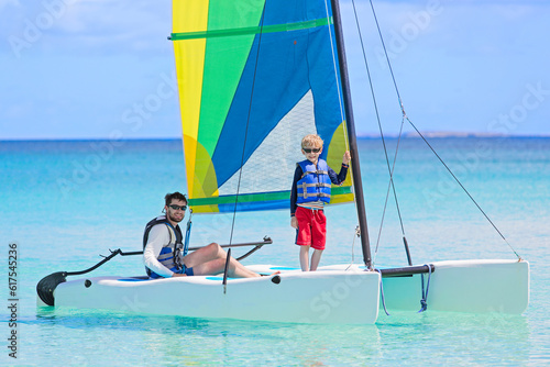 family of two, father and son, enjoying sailing together at hobie cat catamaran, active healthy lifestyle