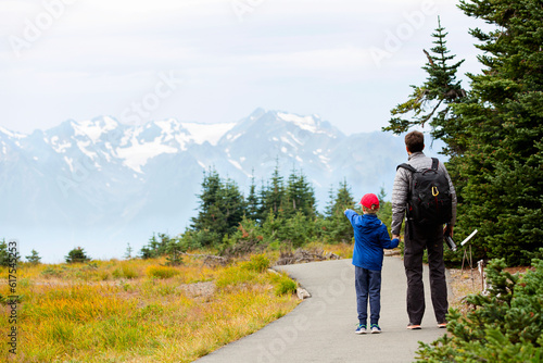 back view of family of two, father and son, enjoying mountain view in olympic national park, washington state, usa, active lifestyle concept photo