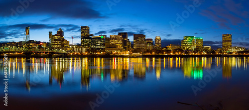 Portland Oregon downtown city skylinw by Hawthorne Bridge along Willamette River at evening blue hour panorama