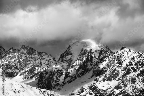 Black and white snow mountains in clouds at sunny winter day. Caucasus Mountains. Svaneti region of Georgia.