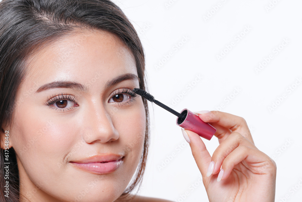 Young female with compact mirror in hand applying eyeliner during daily beauty procedure at home Young female with compact mirror in hand applying eyeliner during daily beauty procedure at home