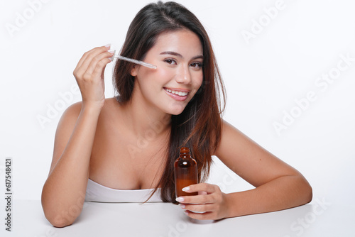 Skin care  pretty girl applies moisturizer on face