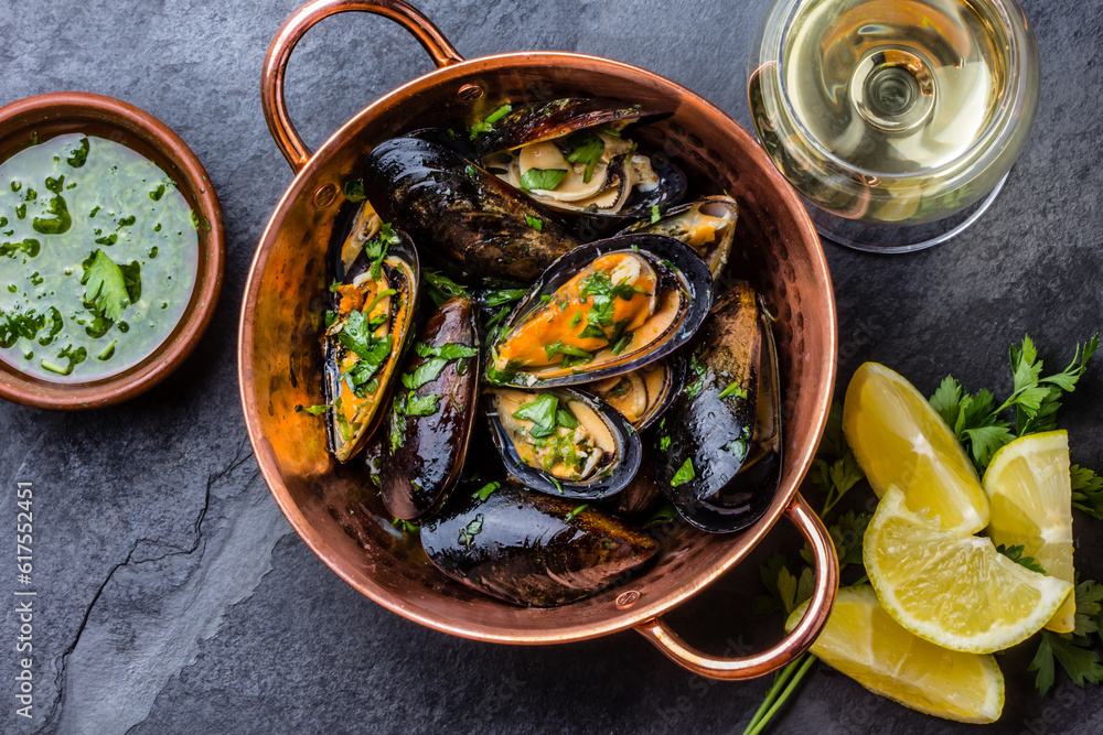 Shellfish Mussels in copper bowl with lemon and herbs sauce and white wine. seafood. Top view Shellfish Mussels in copper bowl with lemon and herbs sauce and white wine. seafood. Top view