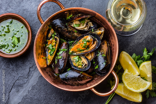 Shellfish Mussels in copper bowl with lemon and herbs sauce and white wine. seafood. Top view