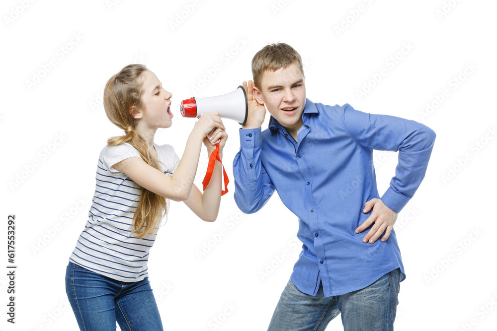 Teen age girl screaming at boy through megaphone. Brother and sister isolated on white background. Copy space. Teen age girl screaming at boy through megaphone. Brother and sister isolated on white background. Copy space.