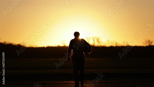 Silhouette of an Air Force Pilot Walking With His Flying Helmet During Sunset at Air Base. 4K Resolution. photo