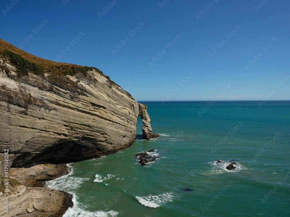 Oceanside cliff natural bridge arch rock formation, coastal nature landscape at Cape Farewell, Tasman New Zealand