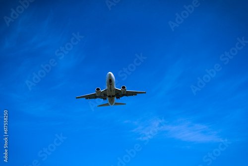 Jet airplane flying overhead close-up on a blue sky background