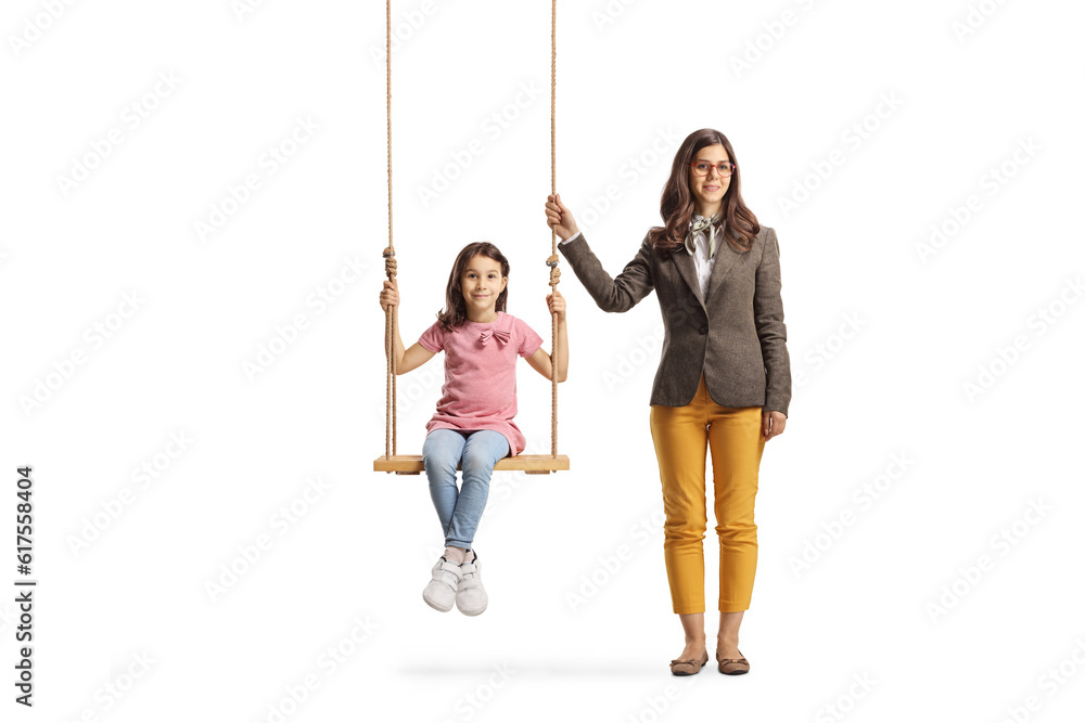 Full length portrait of a young female standing next to a girl on a wooden swing Full length portrait of a young female standing next to a girl on a wooden swing