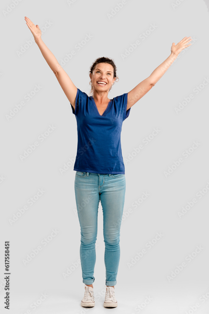 Portrait of a happy middle aged brunette with arms up