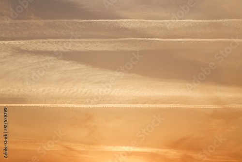 Sunset sky  clouds illuminated by the sun. Contrails and feather clouds.
